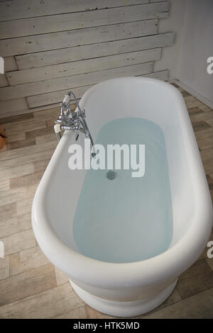 Minimalist bathroom interior. Bath in the middle of the bright room on the window. The view from top Stock Photo