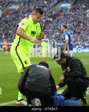 Gelsenkirchen, Germany. 12th Mar, 2017. Augsburg's Raul Bobadilla is treated after an injury during the Bundesliga soccer match between FC Schalke 04 and FC Augsburg at the Veltins Arena in Gelsenkirchen, Germany, 12 March 2017. (EMBARGO CONDITIONS - ATTENTION: Due to the accreditation guidlines, the DFL only permits the publication and utilisation of up to 15 pictures per match on the internet and in online media during the match.) Photo: Ina Fassbender/dpa/Alamy Live News Stock Photo