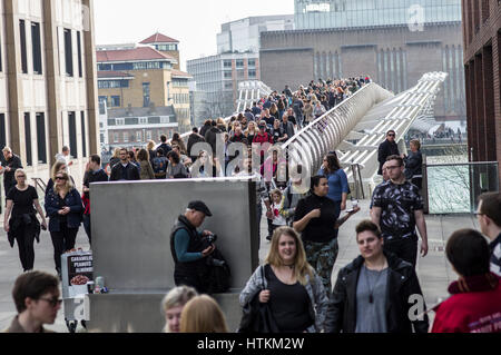 London Millenium Bridge filled with people crossing the Thames River on a busy sunny weekend in March 2017 Stock Photo