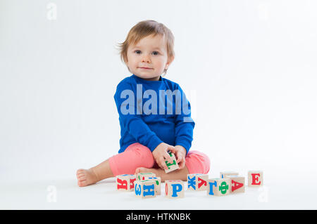 Little child playing with dices isolated on white background Stock Photo