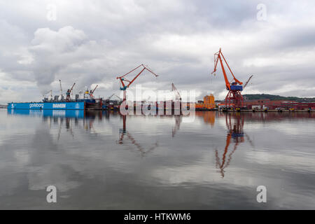 View with water reflections of Gothenburg harbour with cargo cranes and dry dock  Model Release: No.  Property Release: No. Stock Photo