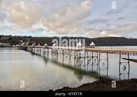 Garth Pier at Bangor with reflections in the water and Anglesey beyond on the other side of the Menai Strait Stock Photo