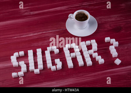 Word SUGAR with question mark made of sugar cubes with cup of espresso Stock Photo