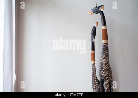 Scrimshaw giraffes from the tree on the background of white walls in a traditional Balinese style Stock Photo
