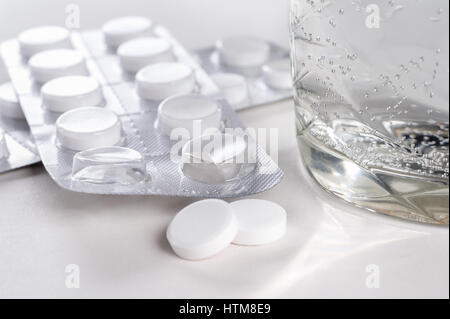 Glass of water and pills in blister pack closeup isolated on white background Stock Photo