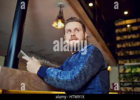 Freelancer man with  tablet in his hands  bar cafe. Stock Photo