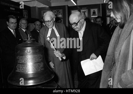 The Poet Laureate Sir John Betjeman striking a mounted bell in the Norman Undercroft at Westminster Abbey to officially open the second of the present series of 'miniature' exhibitions being held there. Stock Photo