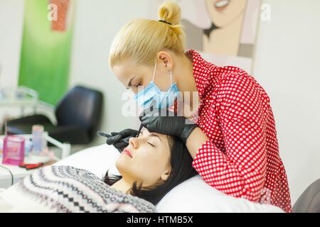 Master lash maker increases eyelashes for young woman Stock Photo