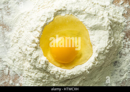 Raw egg and flour on wooden table. Stock Photo
