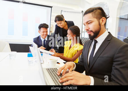 Man as businessman in meeting with laptop working and writing Stock Photo
