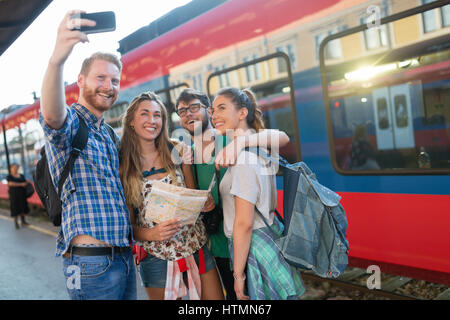 Young group of travelling tourists at train station Stock Photo