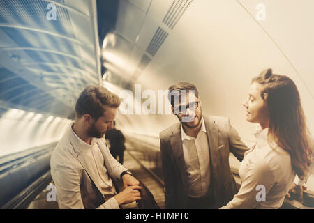 Coworkers using subway stairs together to get underground Stock Photo