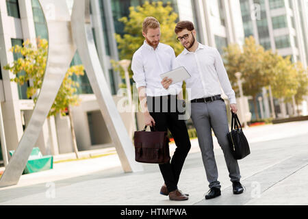 Business colleagues in summer walking and  talking in city Stock Photo