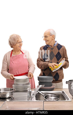 Happy elderly couple washing the dishes together isolated on white background Stock Photo
