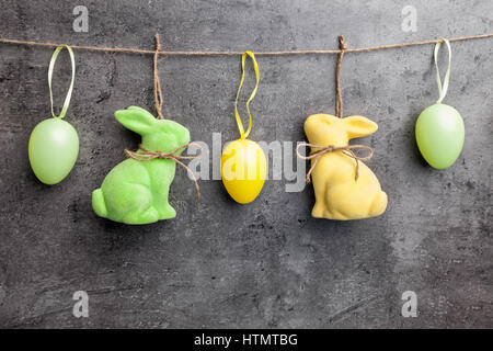 Traditional Easter eggs and bunnies on hanging on rustic background Stock Photo