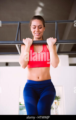 Young woman doing pull-ups in the gym Stock Photo
