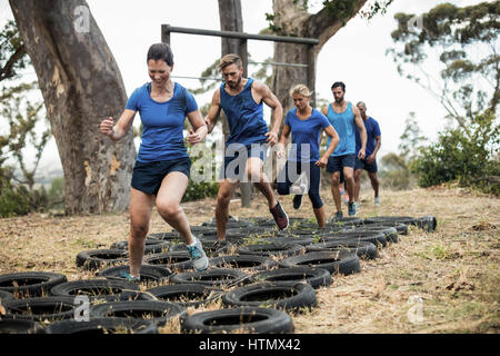 People receiving tire obstacle course training in boot camp Stock Photo