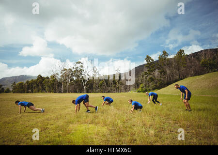 Fit people performing pushup exercise in bootcamp Stock Photo