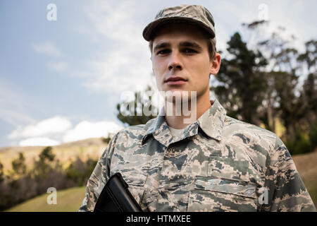 Portrait of military soldier guarding with a rifle in boot camp Stock Photo