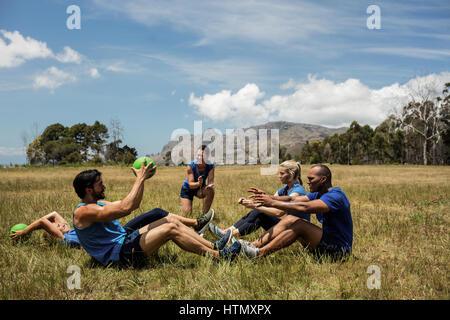 Fit people performing core exercise in bootcamp Stock Photo