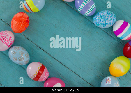 Various Easter eggs forming frame shape on wooden surface Stock Photo