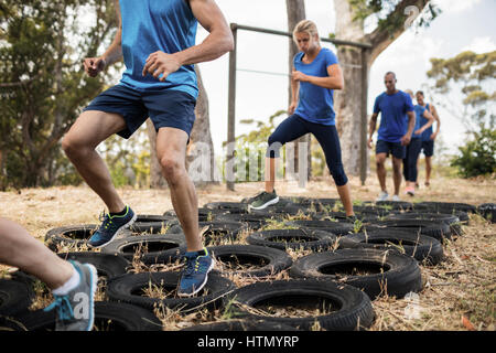 People receiving tire obstacle course training in boot camp Stock Photo