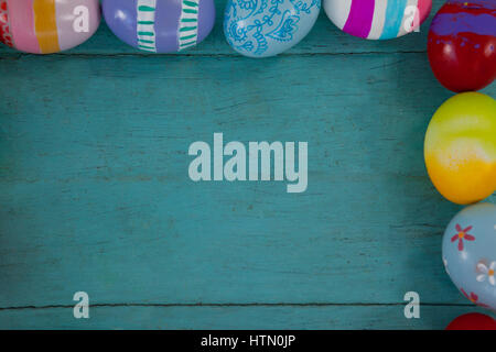 Overhead view of various Easter eggs arranged on wooden surface Stock Photo