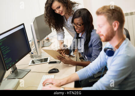 Programmers cooperating at  IT company developing apps Stock Photo