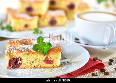 Delicious piece of cherry cake with a fresh cup of cappuccino Stock Photo