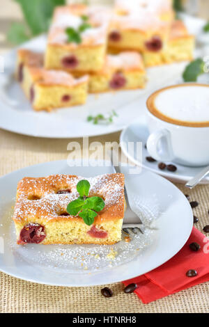 Delicious piece of cherry cake with a fresh cup of cappuccino Stock Photo
