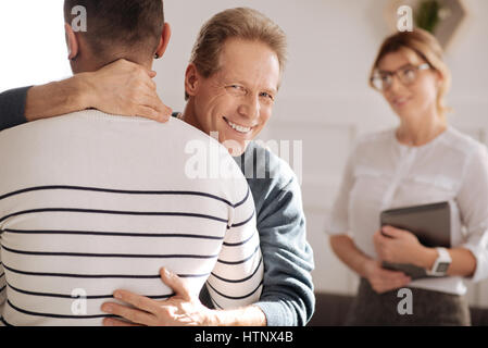 I want to hug you. Happy delighted positive man smiling and hugging his boyfriend while expressing his love to him Stock Photo