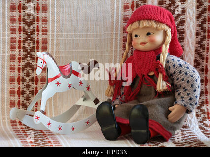 little puppets in national folklore dress Finland  is sitting, beside rocking horse Stock Photo