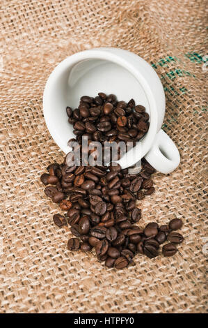 Coffee cup and beans on jute background Stock Photo