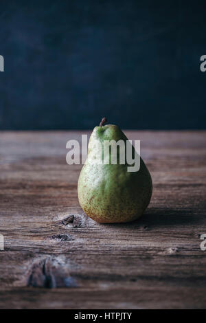 Single pear on a rustic wooden table Stock Photo