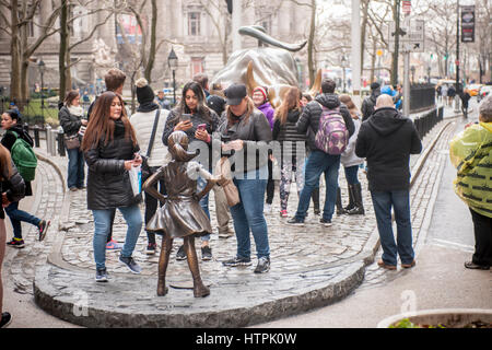 The bronze statue, 'The Fearless Girl' by the artist Kristen Visbal attracted attention at Bowling Green Park in New York on its first day, Tuesday, March 7, 2017. Installed just prior to International Women's Day, it is a campaign by State Street Global Advisors (SSGA) to educate the companies that have women in executive positions perform better and to call on the 3500 companies that collectively have more than $30 trillion in market capitalization to increase the amount of women on their boards. SSGA has the SPDR®SSGA Gender Diversity Index ETF trading under the moniker 'SHE'. (© Richard B. Stock Photo