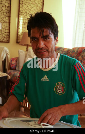 Mexican electrician fixing light fixture in Mexico. Stock Photo