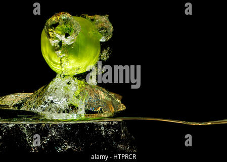 Apples in water with reflrction and splash on black background Stock Photo