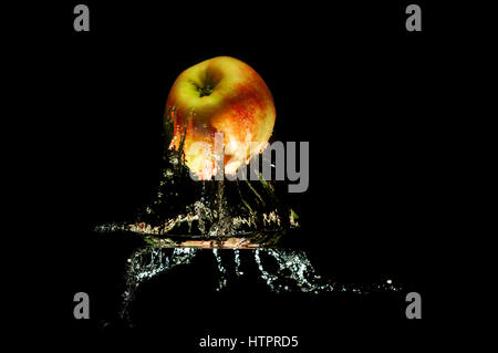 Apples in water with reflrction and splash on black background Stock Photo