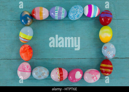 Various Easter eggs forming frame shape on wooden surface Stock Photo