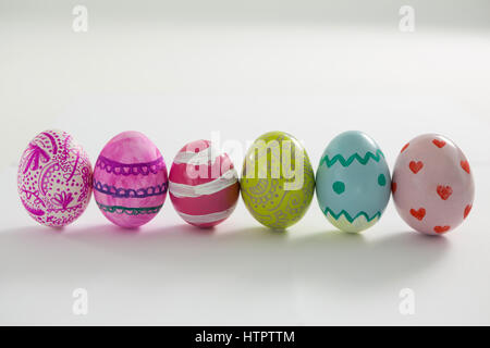 Painted Easter eggs arranged in a row on white background Stock Photo