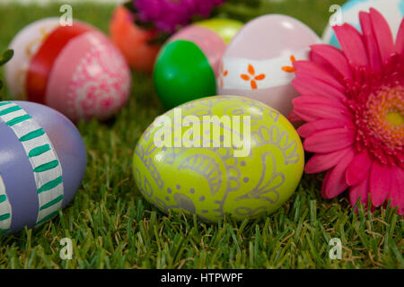 Painted easter eggs with pink flower on grass Stock Photo