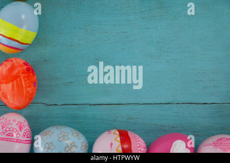 Overhead view of various Easter eggs arranged on wooden surface Stock Photo