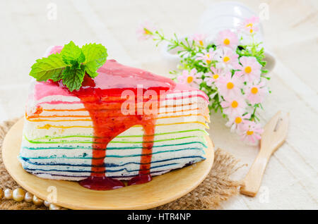 Rainbow crape cake on wooden dish. Stock Photo