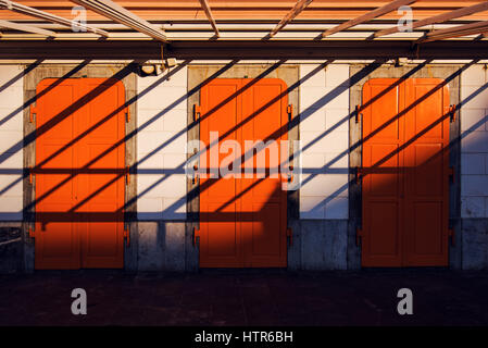 Architecture abstract background, three orange doors and shadows, shapes and lines composition Stock Photo