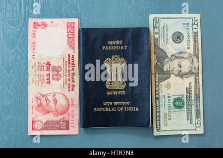 Close-up of Indian 20 Rupee Note and American 20 Dollar bill and Indian Passport on plain background Stock Photo