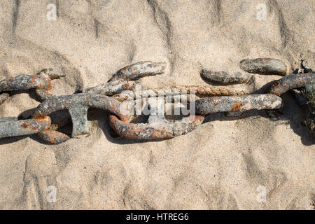 A rusty metal chain on a sandy beach. Stock Photo