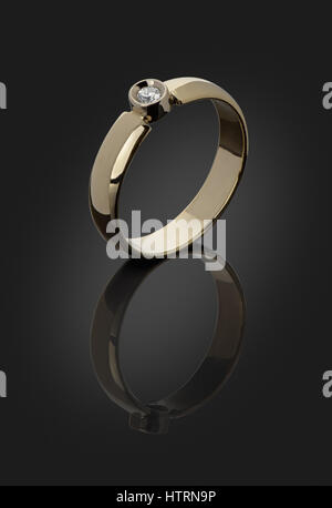 gold ring with a diamond on a dark background is cut with clipping paths Stock Photo
