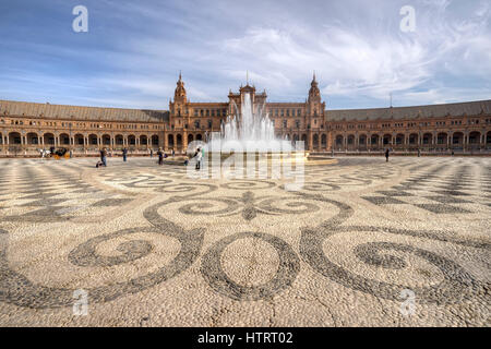 wide angle view of the plaza de espana including the building, fountain and swirling mosaic with dramatic sky backdrop Stock Photo