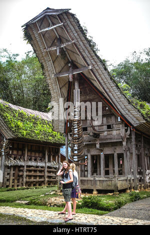 Tourists standing in front of traditional Tongkonan building in Kete Kesu, North Toraja, South Sulawesi, Indonesia. Stock Photo