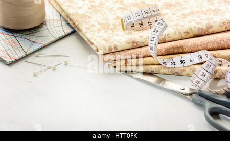 Accessories for sewing and cutting lie on a white table.  Space for an object. Stock Photo